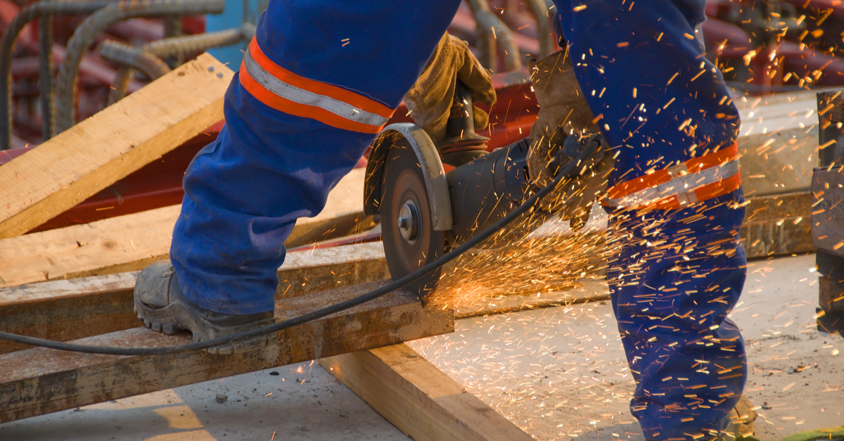 worker cutting wood with a saw