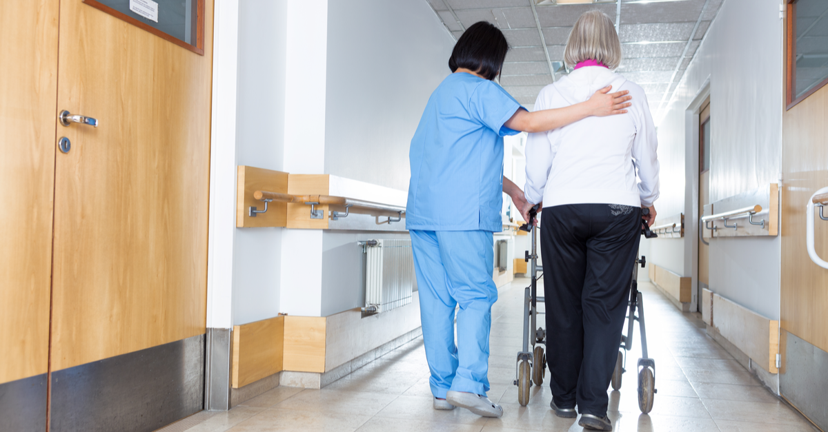Stopping Health Care Workers from Becoming Patients: 3 Ergonomic Injury Risk Prevention Strategies 2 nurse walking an older lady down hallway with walker
