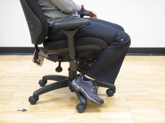 How to Sit Properly At Your Desk 5 woman sitting in chair with feet on the chair legs