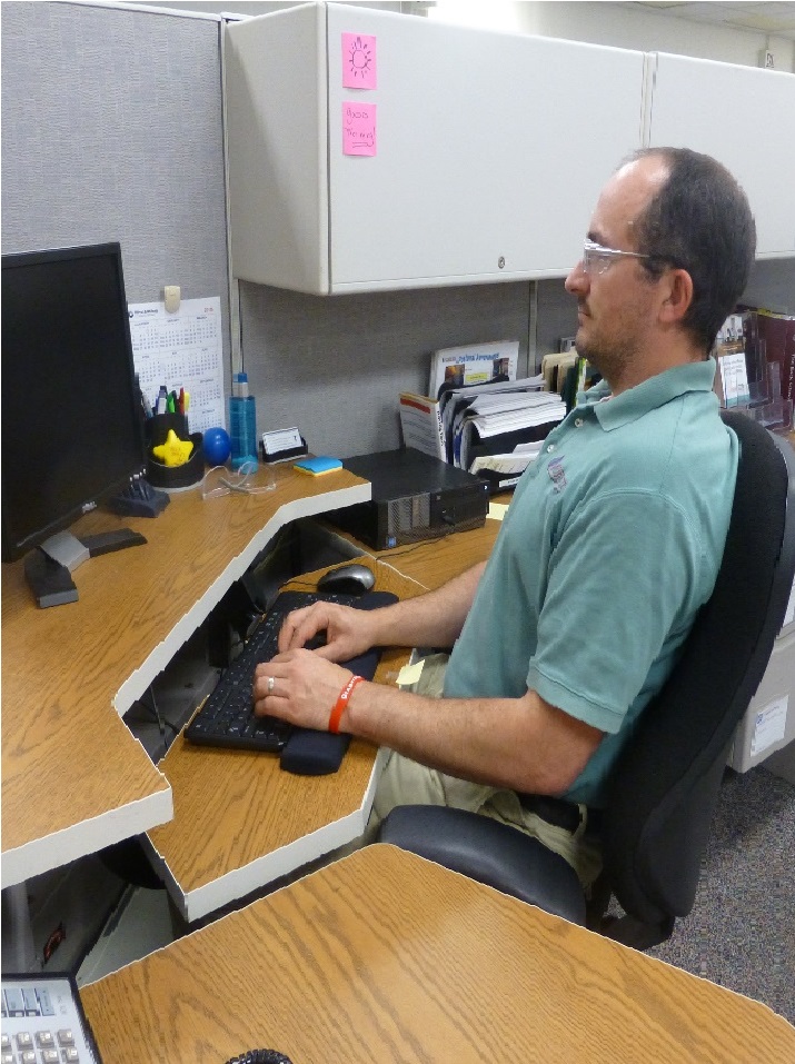 How to Sit Properly At Your Desk 2 man sitting at his desk typing