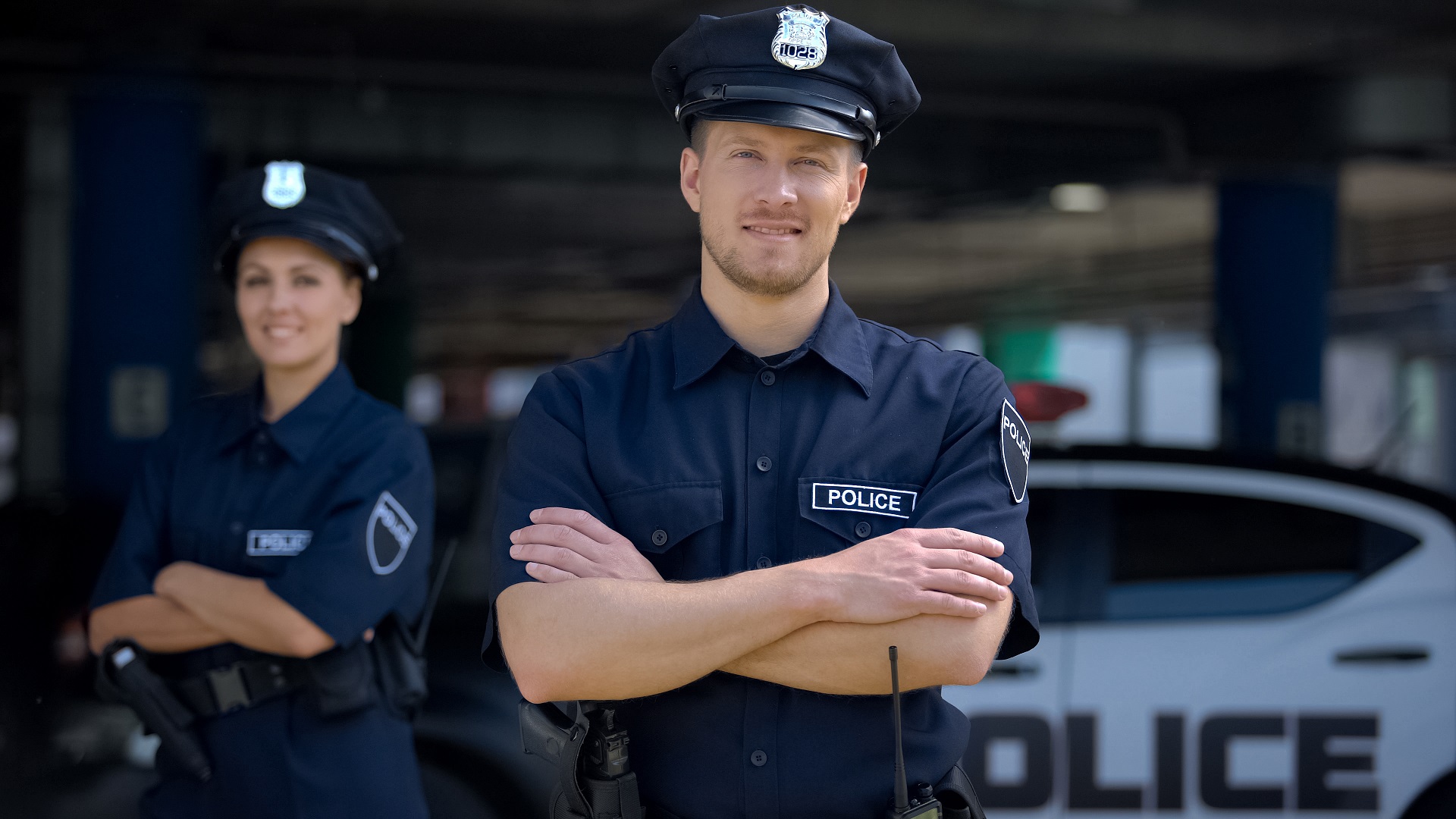 male police officer with female police officer in the back