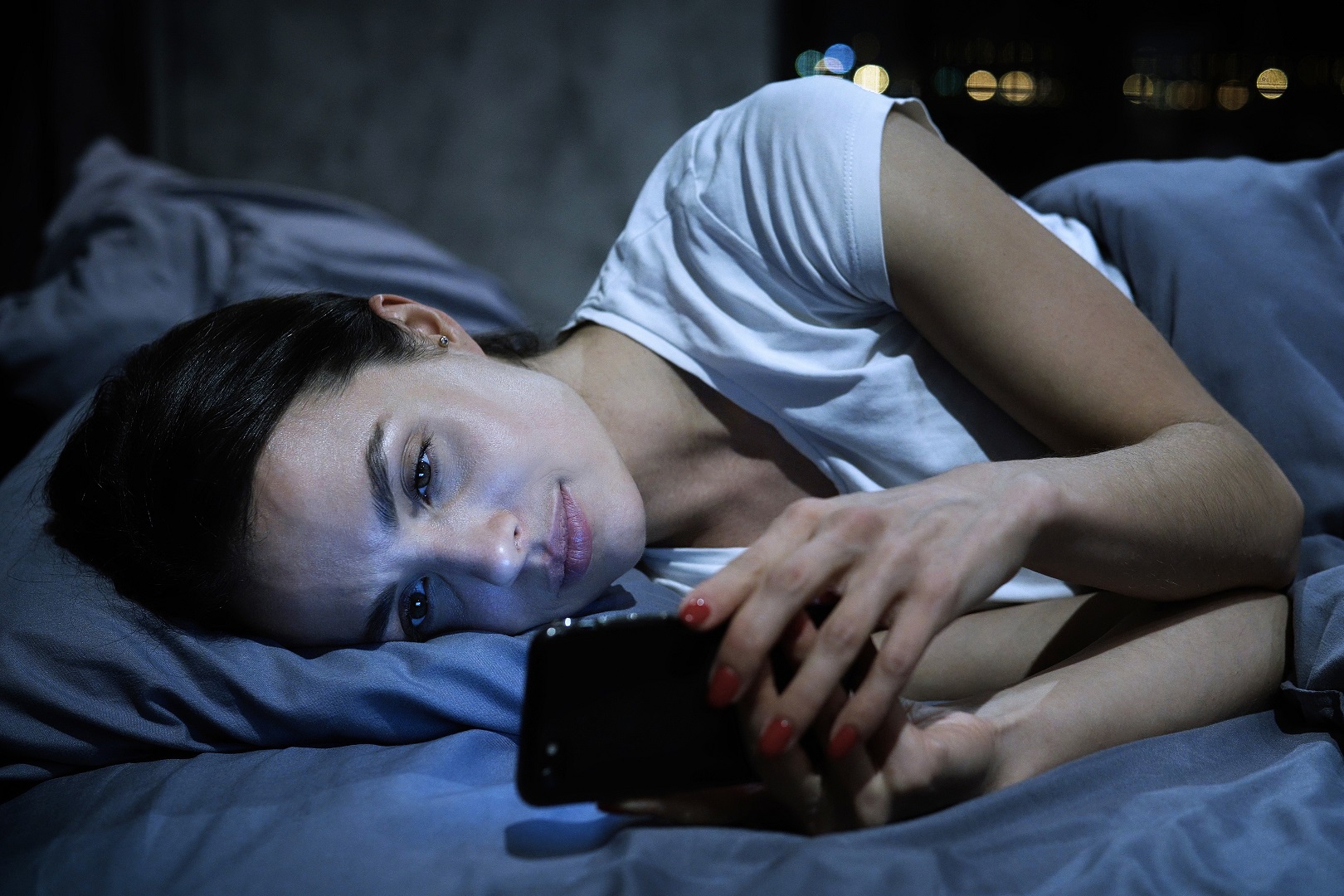 Staying Awake on the Job: Rest, Recovery, and Your Sleep Habits 2 girl in bed on her phone
